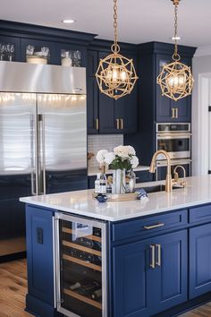 a large kitchen with blue cabinets and white counter tops, an island in the middle