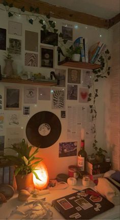 a desk with various items on it including a record player, plant and wine bottle