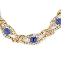 Discover the intersection of age-old tradition and contemporary design with this exquisite collar necklace from M. Gerard. Crafted in luxurious 18K yellow gold, this piece showcases nine mesmerizing cabochon-cut blue sapphires, each radiating a deep, alluring hue. The sapphires, ranging from approximately 15.5 x 8.5 x 5.0 to 7.7 x 7.6 x 4.5 mm, are elegantly complemented by round diamonds, creating a captivating openwork design that adds a touch of brilliance.With a total diamond weight of approximately 32.00 to 36.00 carats, this necklace exudes opulence and sophistication. The 14-inch length ensures a graceful drape around the neck, making it a statement piece for any formal occasion. Signed by M. Gerard and adorned with French assay and workshop marks, this necklace is a testament to fi Luxury Round Cut Sapphire Necklace, Luxury Sapphire Necklace With Round Cut, Luxury Heirloom Yellow Sapphire Jewelry, Luxury Heirloom Sapphire Jewelry, Luxury Sapphire Necklaces With Polished Finish, Luxury Sapphire Necklace With Bezel Setting, Luxury Handmade Sapphire Necklaces, Luxury Sapphire Gold Plated Jewelry, Exquisite Luxury Sapphire Necklace