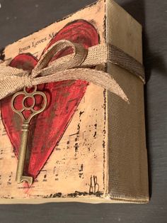 a wooden box with a key tied to it and a heart on top that says love