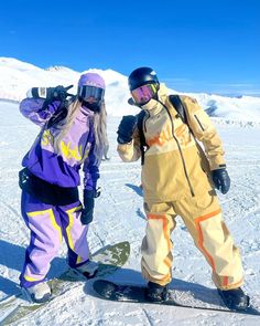 two snowboarders are posing for the camera