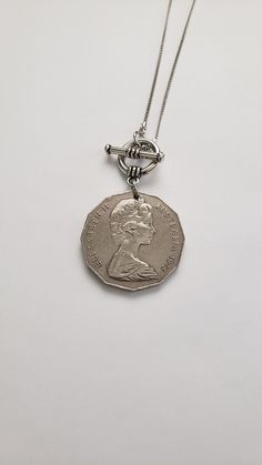 "For your favorite Australian, this necklace will be a treasure! It features a 1975 Australian 50-cent coin with the image of Queen Elizabeth on one side and an emu and kangaroo on the reverse side. The coin dangles from a 16\" silver-tone chain with a front toggle closure that enhances the overall look of this necklace. Welcome to Recycled Finery!  I repurpose old jewelry, coins, beads, vintage buttons, watch parts, and charms into new jewelry.  My ever-growing collection of these materials comes from estate sales, rummage sales, antique and thrift stores, and family and friends' collections they no longer need or want. I have fun putting these new pieces together and hope that you will find them fun to wear and as unique gifts for your loved ones.  Thank you for your interest and purchas Toggle Necklace With Coin Pendant, Silver Toggle Necklace With Coin Pendant As Gift, Vintage Coin Necklace With Round Pendant, Vintage Metal Coin Necklace With Round Pendant, Vintage Round Pendant Coin Necklace, Vintage Sterling Silver Charm Necklace With Lobster Clasp, Vintage Silver Coin Charm Necklaces, Silver Medallion Jewelry With Toggle Clasp, Medallion Toggle Necklace With Coin Pendant As Gift