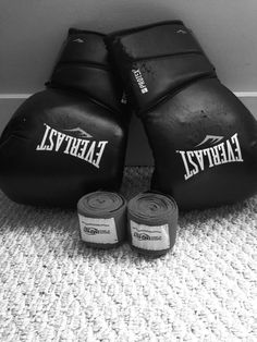 two boxing gloves sitting on the floor next to each other