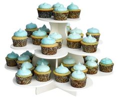 cupcakes with blue frosting are stacked on top of each other in the shape of a four - tiered cake stand