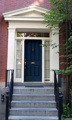 a blue door is on the side of a red brick building