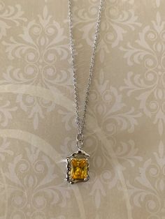 "Pretty and dainty square yellow crystal with irregular design silver tone edging.  Pendant measures 5/8\" L X 1/2\" W and is on an 18\" chain.  ★ Want to see more?  Please visit my shop at: https://www.etsy.com/shop/DesignsByPeg" Yellow Topaz Necklace, Yellow Stone Jewelry, Yellow Stone Pendant, Mcu Oc, Emerald Green Jewelry, Yellow Pendant, Fruit Necklace, Prom Inspo, Yellow Gems