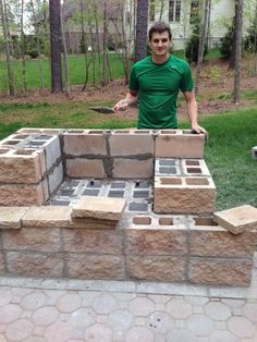 a man standing in front of a fire pit made out of bricks and cinder blocks