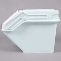 a white plastic container sitting on top of a gray surface with the lid up and two handles down