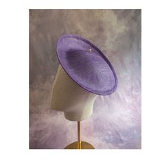 One contoured saucer fascinator / hat base with a modified upturned brim in light purple sinamay straw that measures approximately 9.5" (24.13 cm).  The base is contoured to fit against the head. The edges of the brim are finished in wired sinamay. The multi-layer stiffened sinamay straw has a great sturdy weave and provides excellent support for your millinery creations. NOTE: This is NOT a finished hat and will not stay on your head unless you add a head band or clips to wear. This base does have a small sleeve sewn into the crown that will accomodate a narrow headband or an alligator clip - listed separately in my shop. Add embellishments of your choice. Sinamay is a natural material and you may see some color striations in the weave. This is not a defect, but is the result of how diffe Fitted Hat With Round Crown For Kentucky Derby, Fitted Purple Hat For Spring, Purple Brimmed Summer Fascinator, Purple Short Brim Top Hat For Summer, Fitted Purple Hat With Short Brim, Purple Mini Hats For Summer Church Events, Purple Mini Hats For Summer Church, Summer Wide Brim Purple Costume Hat, Purple Wide Brim Summer Costume Hat