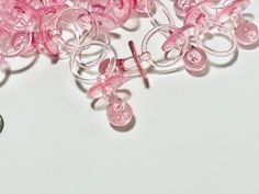 a pile of pink plastic buttons sitting on top of a white table next to a coin