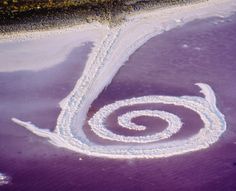 an aerial view of a spiral shaped object in the water with snow on it's surface