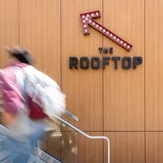 a man walking down an escalator in front of a building