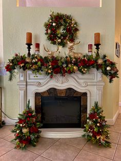 a fireplace decorated for christmas with wreaths and candles