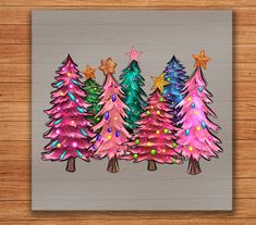 three christmas trees with lights and stars on them are in front of a wood background