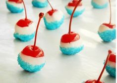 blue, white and red desserts with cherries on the top are ready to be eaten