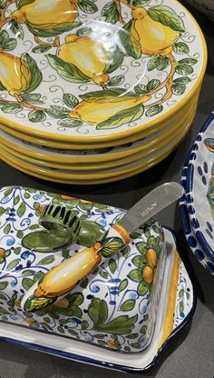 a table topped with plates and bowls filled with lemons on top of each other