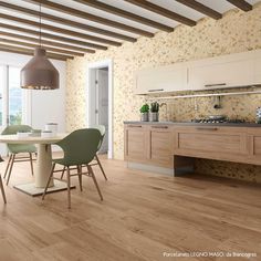 a dining room table and chairs in front of an open kitchen with wood flooring