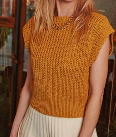 a woman with blonde hair wearing a yellow sweater