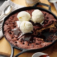 a skillet with chocolate cake and ice cream on it next to a cup of coffee