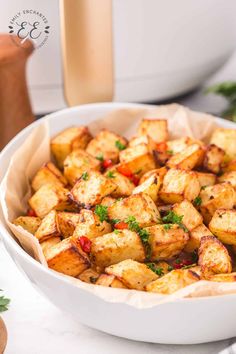 a white bowl filled with cooked tofu and garnished with parsley on the side