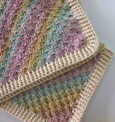 two crocheted blankets sitting next to each other