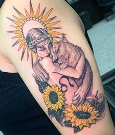 a woman's arm with sunflowers and a cat tattoo on her shoulder