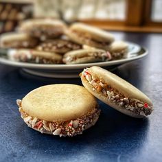 two plates filled with cookies on top of a blue table next to another plate full of cookies