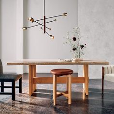 a wooden table with two chairs and a vase on it