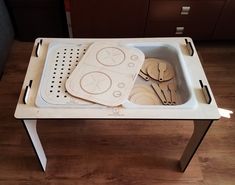 a tray with utensils and spoons in it sitting on a table top