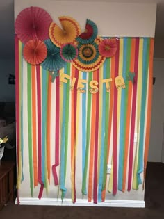 colorful streamers and paper umbrellas are hanging on the wall in front of a fiesta sign