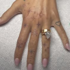 a woman's hand with tattoos on it and a diamond ring in the middle