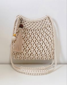 a crocheted white purse with tassels