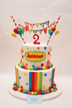 a two tiered birthday cake with colorful decorations