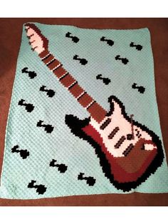 a crocheted blanket with an electric guitar on it