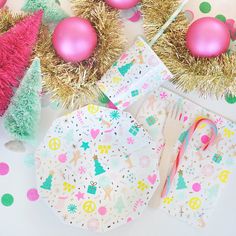 a table topped with plates and napkins covered in christmas decorations next to tinsel