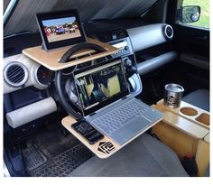 a laptop computer sitting on top of a wooden desk in the back of a truck