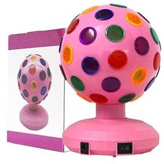 a pink toy with multicolored polka dots on it next to a photo frame