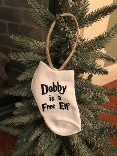 a christmas tree with a white bag hanging from it's top and the words dobby is a free elk on it