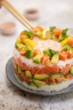 a plate with rice, salmon and avocado on it