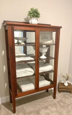 a wooden cabinet with towels on it in a room that has carpeted flooring