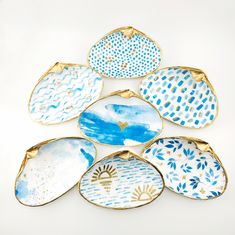 six blue and white plates sitting on top of each other in the shape of leaves