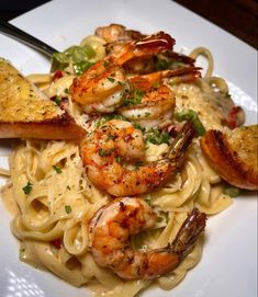 a white plate topped with pasta and shrimp