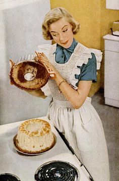 a woman in an apron holding a pancake on top of a stove next to a pie