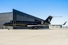 an airplane is parked in front of a hangar