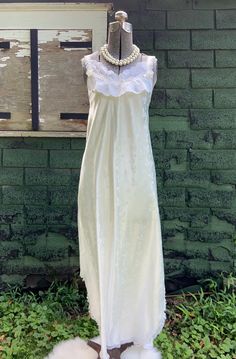 Vintage embossed cream nightgown, Carole Hochman Bonwit Teller. This vintage cream nightgown features a sleeveless V-neck style top trimmed in white lace with floral embellishments on the lace and ribbon straps, 2 side slits, and lace trim around the hem. Great condition; no flaws to note.  Original label tag attached and reads Carole Hochman  Bonwit Teller Size small; see measurements below: Measurements:   Chest (taken with garment lying flat from pit-to-pit): 15" Waist (taken with garment lying flat from side seam-to-seam): 17" Length from middle back to bottom: 44" All the items I list in my store are vintage or antique. Some treasures will show signs of wear or age, and I will always do my best to list any flaws, marks or honest repairs.  Please carefully study all the item photos for White Sleeveless Sleepwear With Delicate Lace, Sleeveless Sleepwear With Lace Trim For Wedding, Sleeveless Wedding Sleepwear With Lace Trim, Sleeveless Lace Nightgown With Delicate Detail, Sleeveless Lace Bodice Nightgown, White Vintage Sleepwear With Delicate Lace, Sleeveless Cream Nightgown For Wedding, Feminine Cream Nightgown With Lace Trim, Sleeveless Lace Nightgown For Home