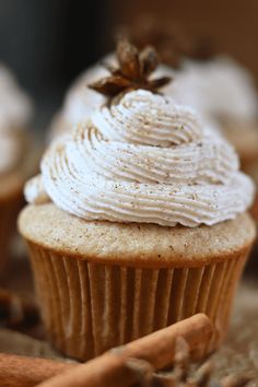 a cupcake with white frosting and cinnamon sticks