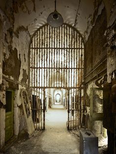 an old jail cell with bars on the walls and doors that lead to another room