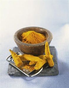 a wooden bowl filled with yellow powder next to two bananas on a metal tray,