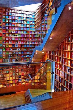 the inside of a library with many bookshelves and stairs leading up to it