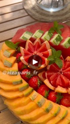 a fruit platter with watermelon, oranges and strawberries on it